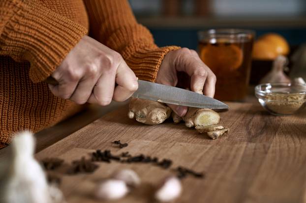 Close,Up,Of,Caucasian,Woman,Cutting,Ginger,In,Kitchen