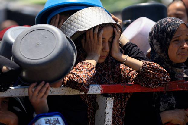 Palestinians gather to receive food from charity kitchen, in Gaza City