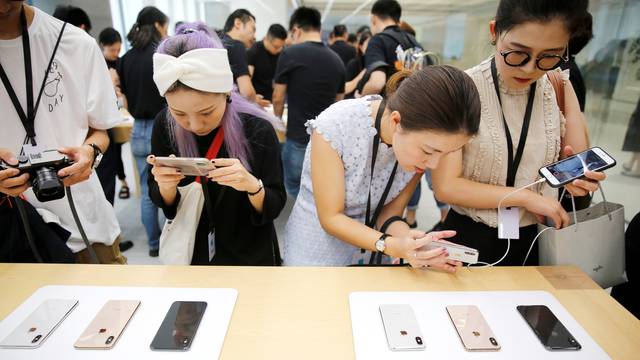 People experience new Apple's iPhone XS and iPhone XS Max during a media tour at an Apple office in Shanghai