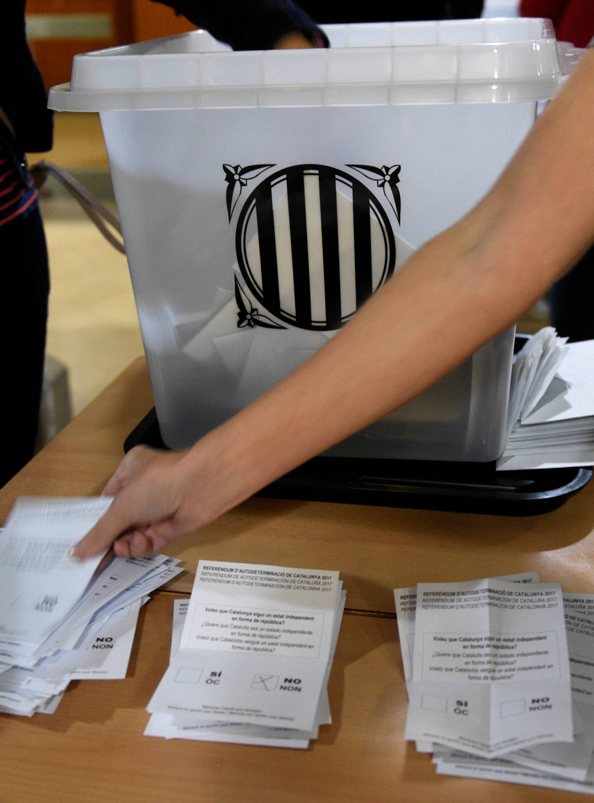 Poll workers count ballots after polls closed at a polling station for the banned independence referendum in Barcelona