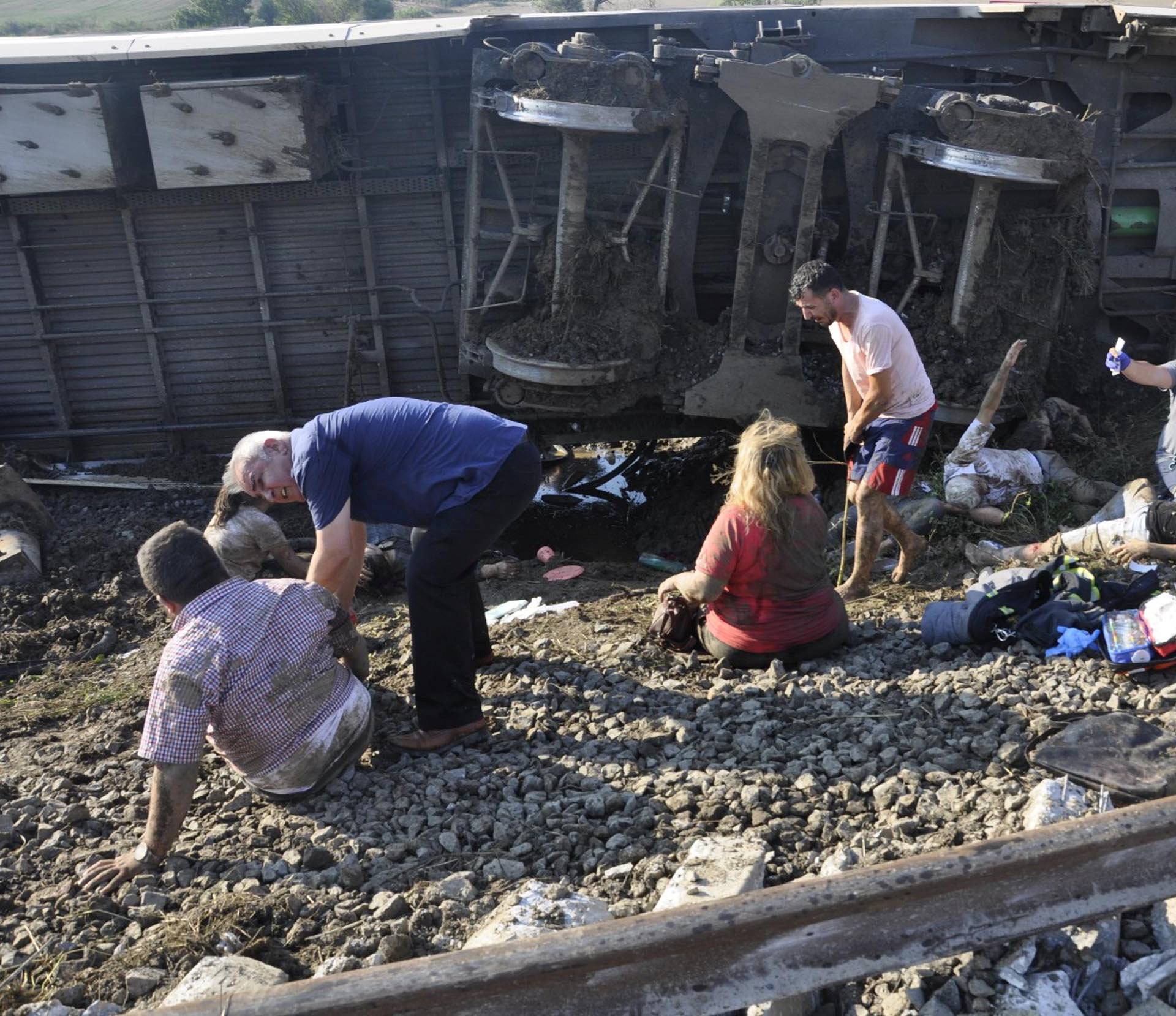 People receive help from medical personnel after a train came off the rails due to heavy rain and a landslide on to the tracks near Corlu in Tekirdag province