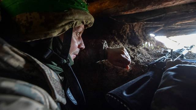 A Ukrainian service member is seen in a trench at a position on a front line near the city of Bakhmut