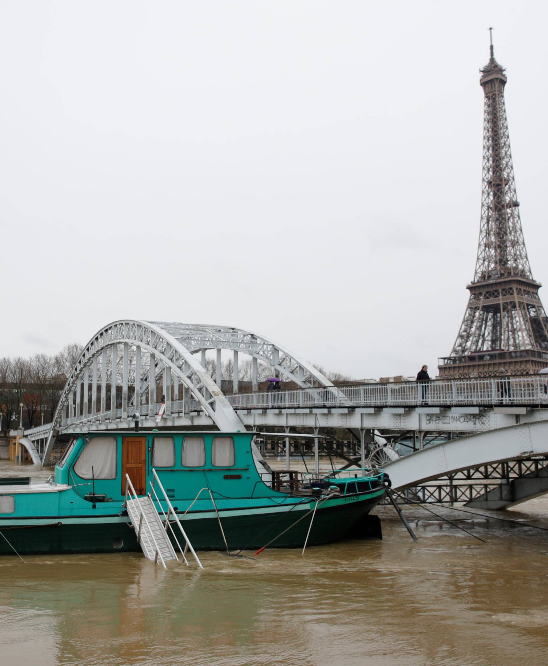 Houseboats are moored near the Eiffel Tower as high waters cover the banks of the Seine River in Paris