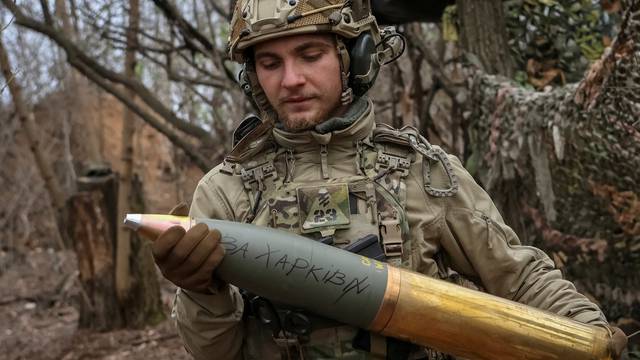 FILE PHOTO: A serviceman of the National Guard of Ukraine prepares a shell for a howitzer at a position in a front line in Donetsk region