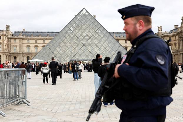FILE PHOTO: A French CRS riot police officer patrols near the glass Pyramid of the Louvre Museum