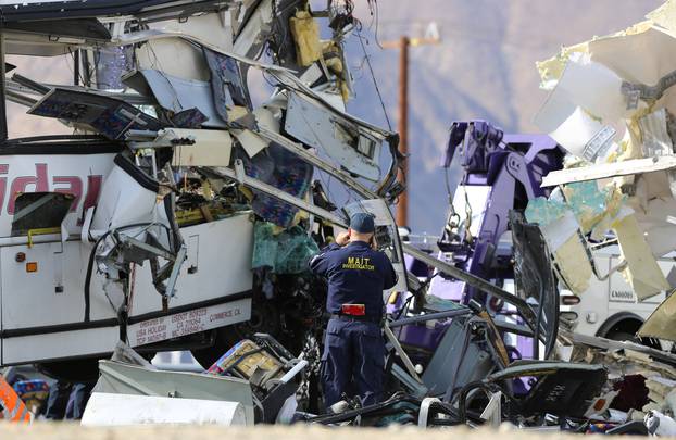 An investigator documents the scene of a mass casualty bus crash on the westbound Interstate 10 freeway near Palm Springs, California