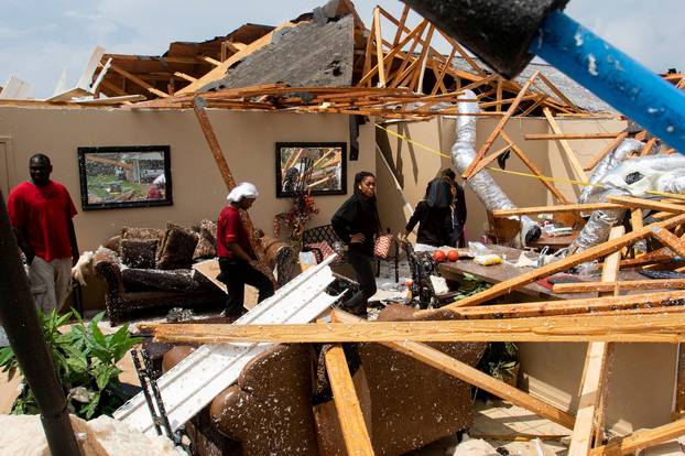 Residents comb through the wreckage of a collapsed house after an Easter Sunday tornado in Monroe