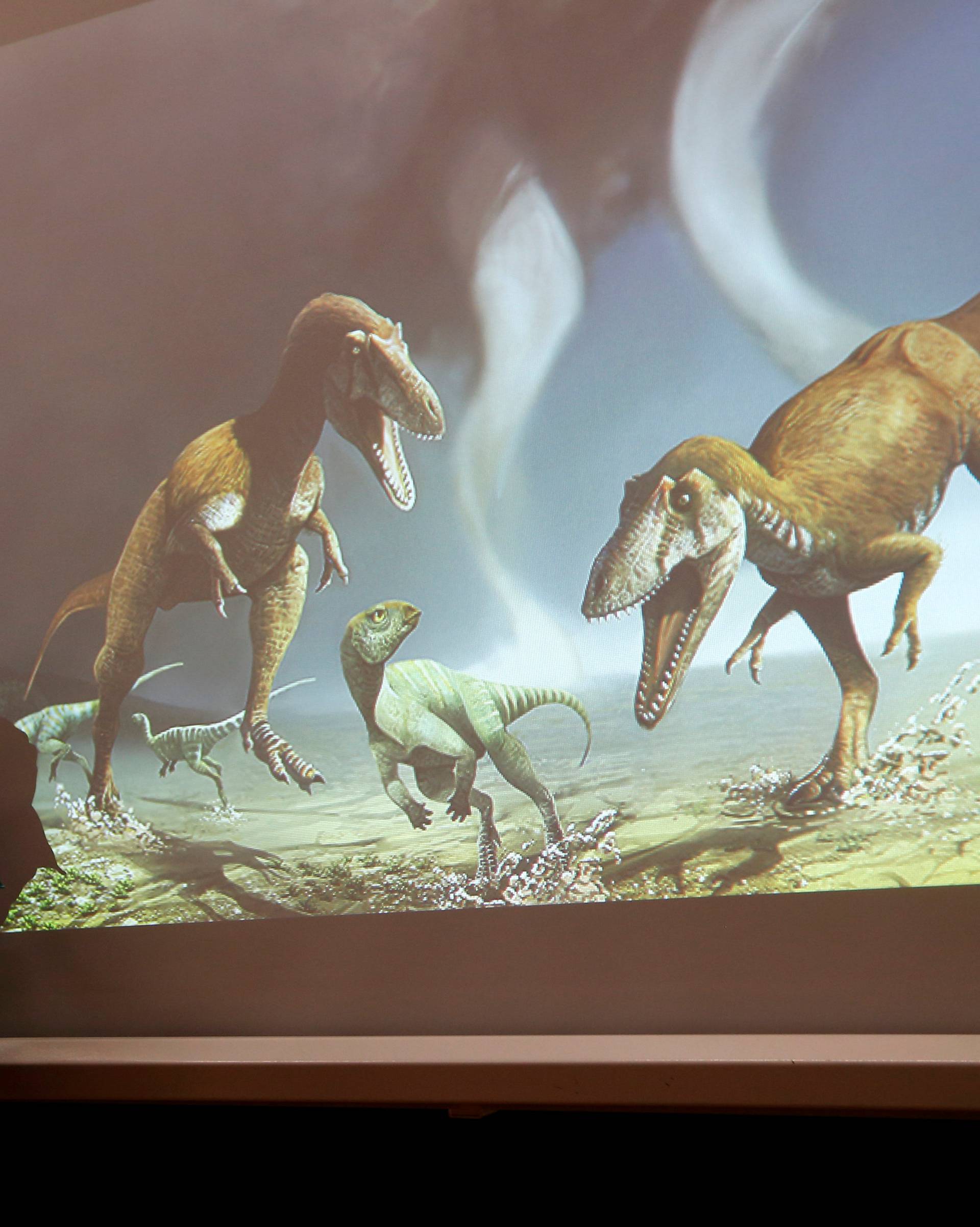 Argentine paleontologist Apesteguia speaks next to a screen showing two Cretaceous Period predatory dinosaurs named Gualicho in northern Patagonia 90 million years ago in Buenos Aires