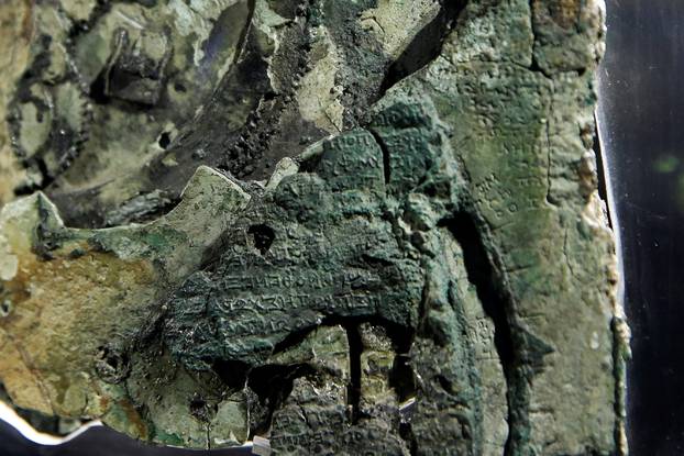 Detail of a fragment of the ancient Antikythera Mechanism displayed at the National Archaeological Museum in Athens