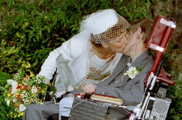 A kiss for scientist and theorist Stephen Hawking from his new bride Elaine Mason after their civil ..