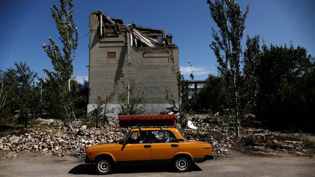 62-year-old Ukrainian Arkadii drives a car after leaving his destroyed house, as Russia's attack on Ukraine continues, in Toretsk