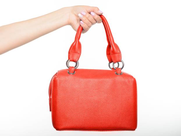female hand holding red bag isolated