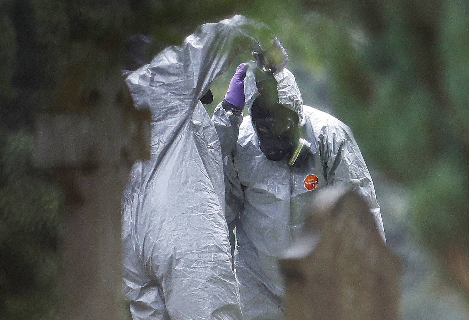 Members of the emergency services help each other to remove their protective suits at the site of the grave of Luidmila Skripal, wife of former Russian inteligence officer Sergei Skripal, at London Road Cemetery in Salisbury