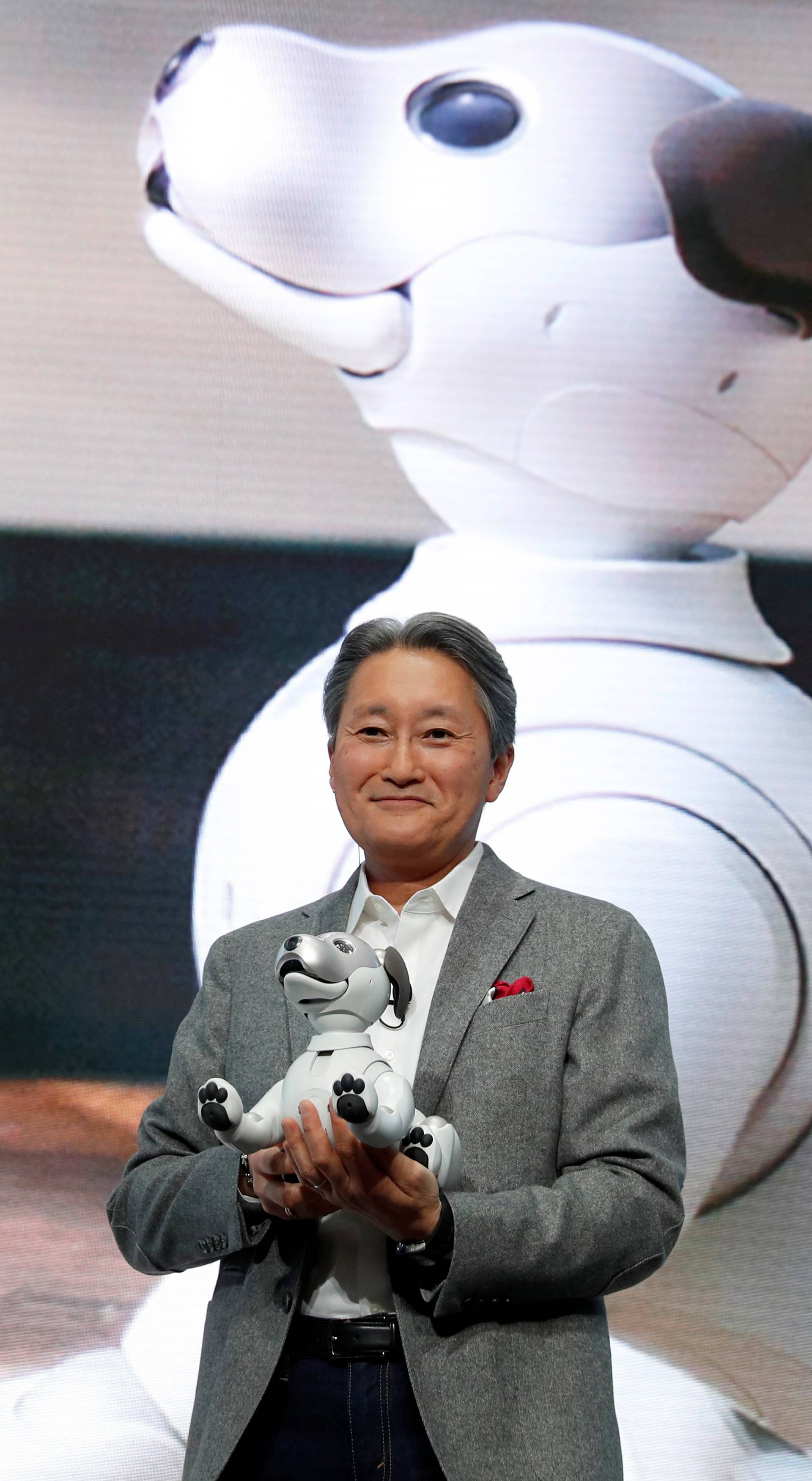 Kazuo Hirai, president and CEO of Sony Corporation, holds an Aibo robotic dog during a news conference at the 2018 CES in Las Vegas