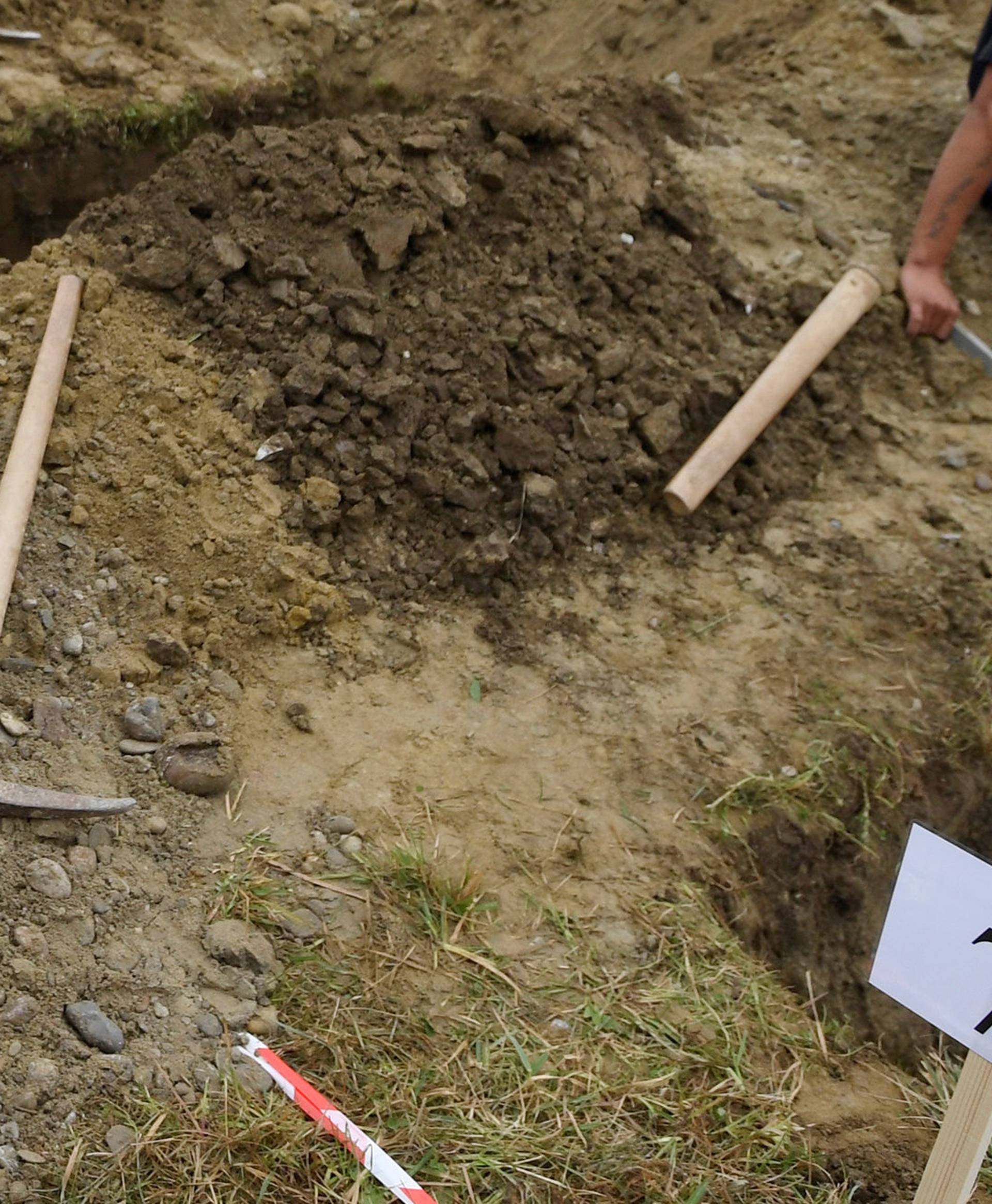 Gravediggers rest after competing in a grave digging championship in Trencin, Slovakia