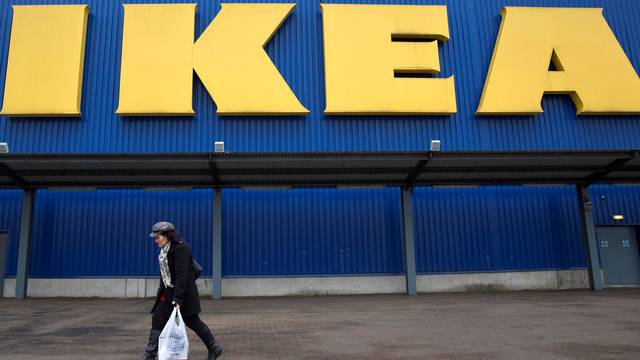 FILE PHOTO: A shopper walks past a sign outside an IKEA store in Wembley, north London