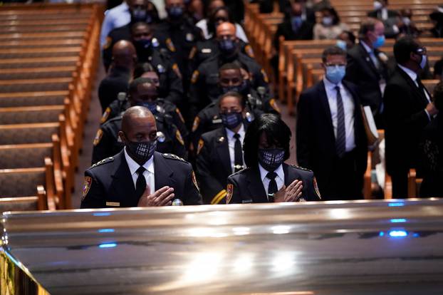Members of the Texas South University police department pause by the casket of George Floyd during a funeral service at the Fountain of Praise church, in Houston