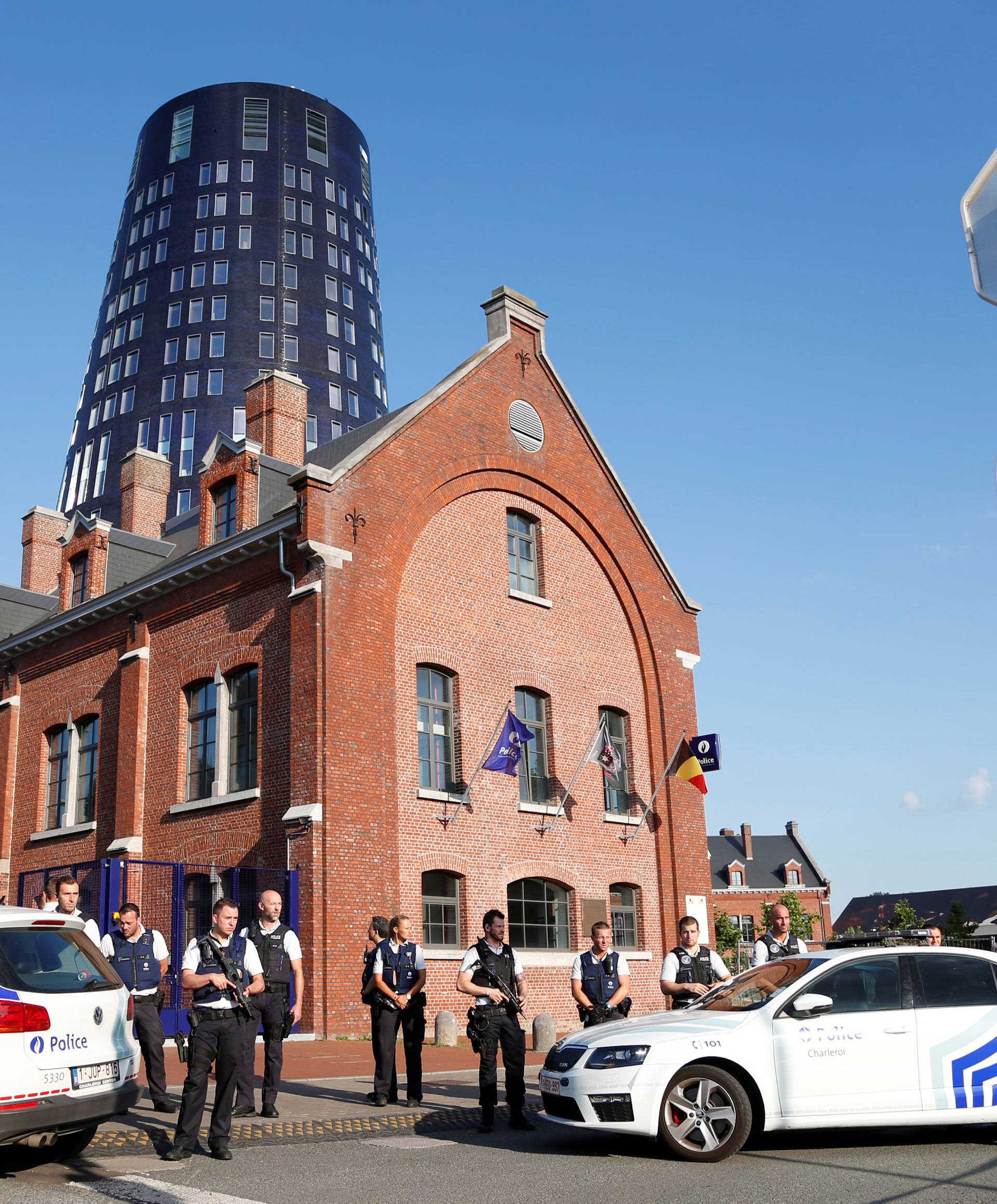 Belgian police officers stand guard outside the main police station after a machete-wielding man injured two female police officers before being shot in Charleroi