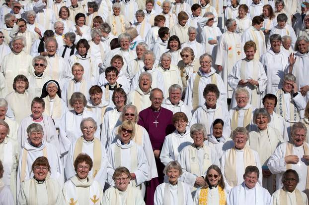 FILE PHOTO: The Archbishop of Canterbury Justin Welby poses with female priests after their march celebrating the twentieth anniversary of women becoming ordained priests in the Church of England in London