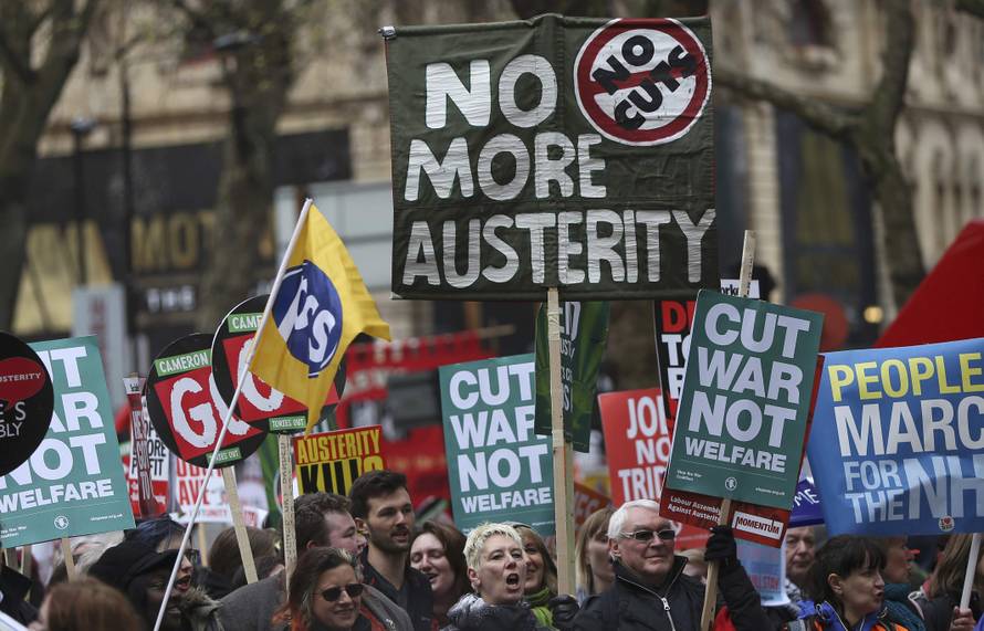 Demonstrators hold placards during an anti-austerity protest in London