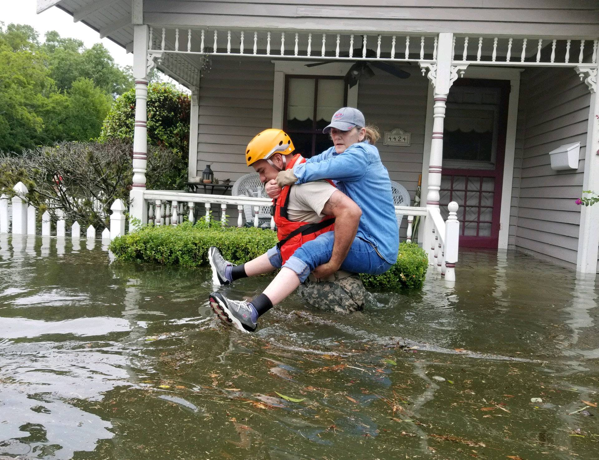 Handout photo of a Texas National Guard soldier carries a woman on his bank as they conduct rescue operations in flooded areas around Houston