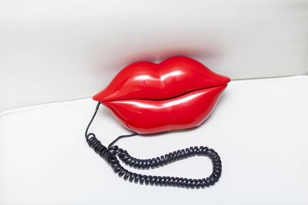 Red,Lips,Telephone,With,Black,Cable,On,White,Leather,Couch