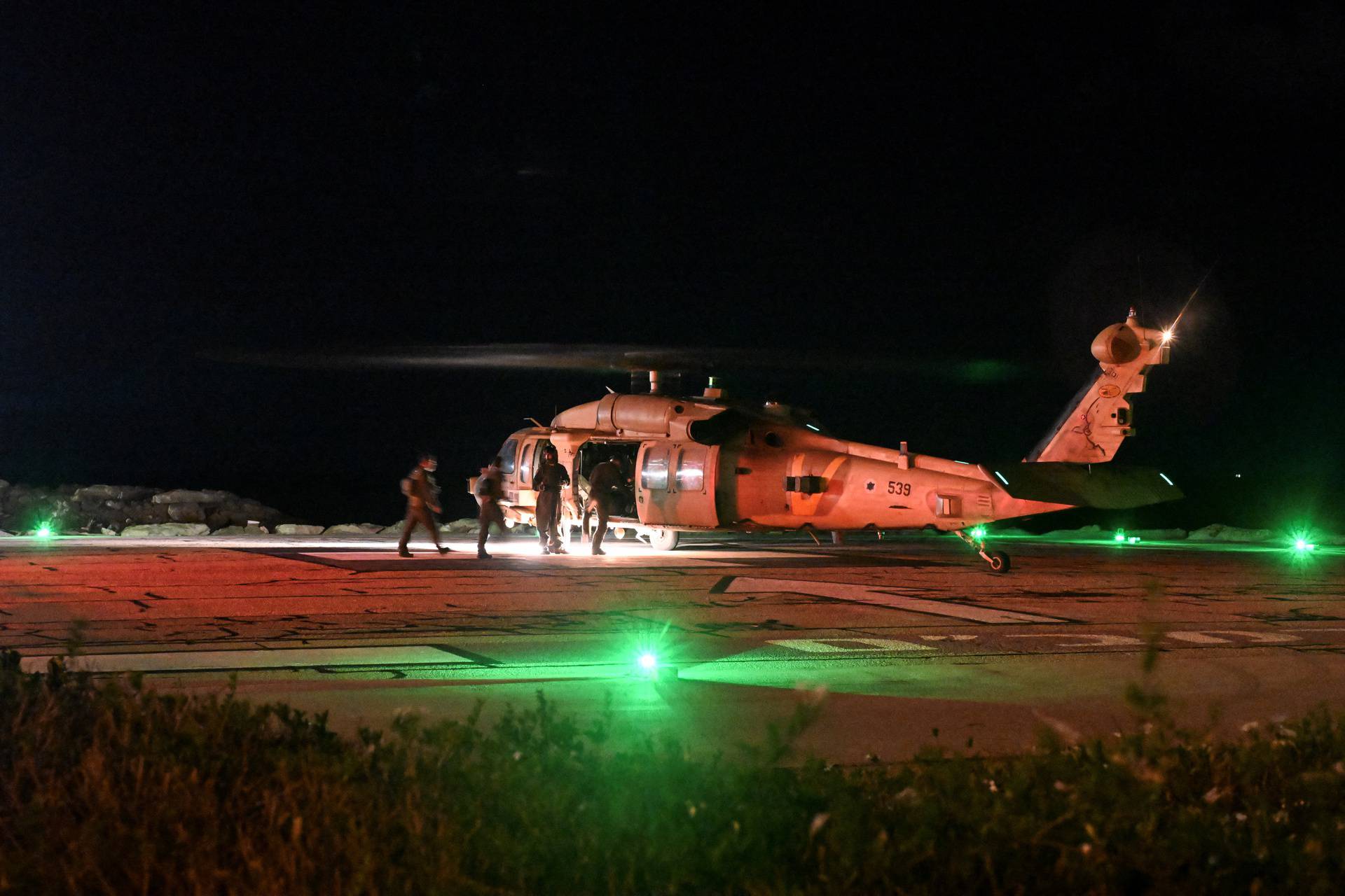 Israeli soldiers enter a military helicopter after it dropped off patients that were injured in a drone attack from Lebanon, at Rambam Health Care Campus in Haifa