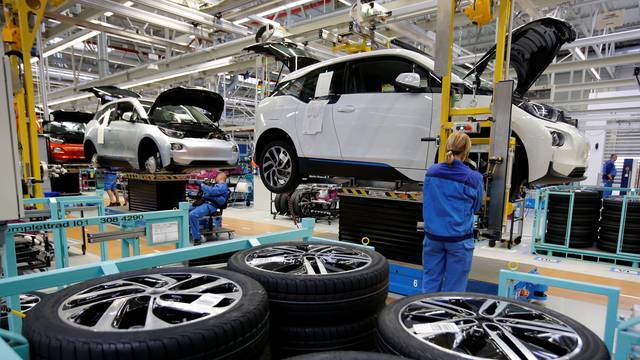 FILE PHOTO: A worker mounts a tyre at the serial production BMW i3 electric car in the BMW factory in Leipzig