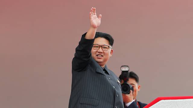 North Korean leader Kim Jong Un waves to the crowd as he presides over a mass rally and parade in Pyongyang