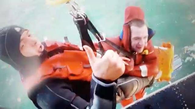 A still image taken from a video shows a member of Turkish Coast Guard Command escorts a sailor as he is pulled up into a helicopter off Black Sea port city of Samsun