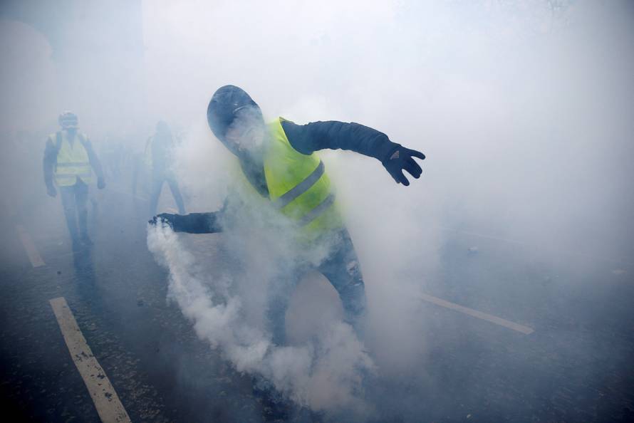 A protester wearing a yellow vest, a symbol of a French drivers' protest against higher diesel taxes, demonstrates near the Place de l'Etoile in Paris