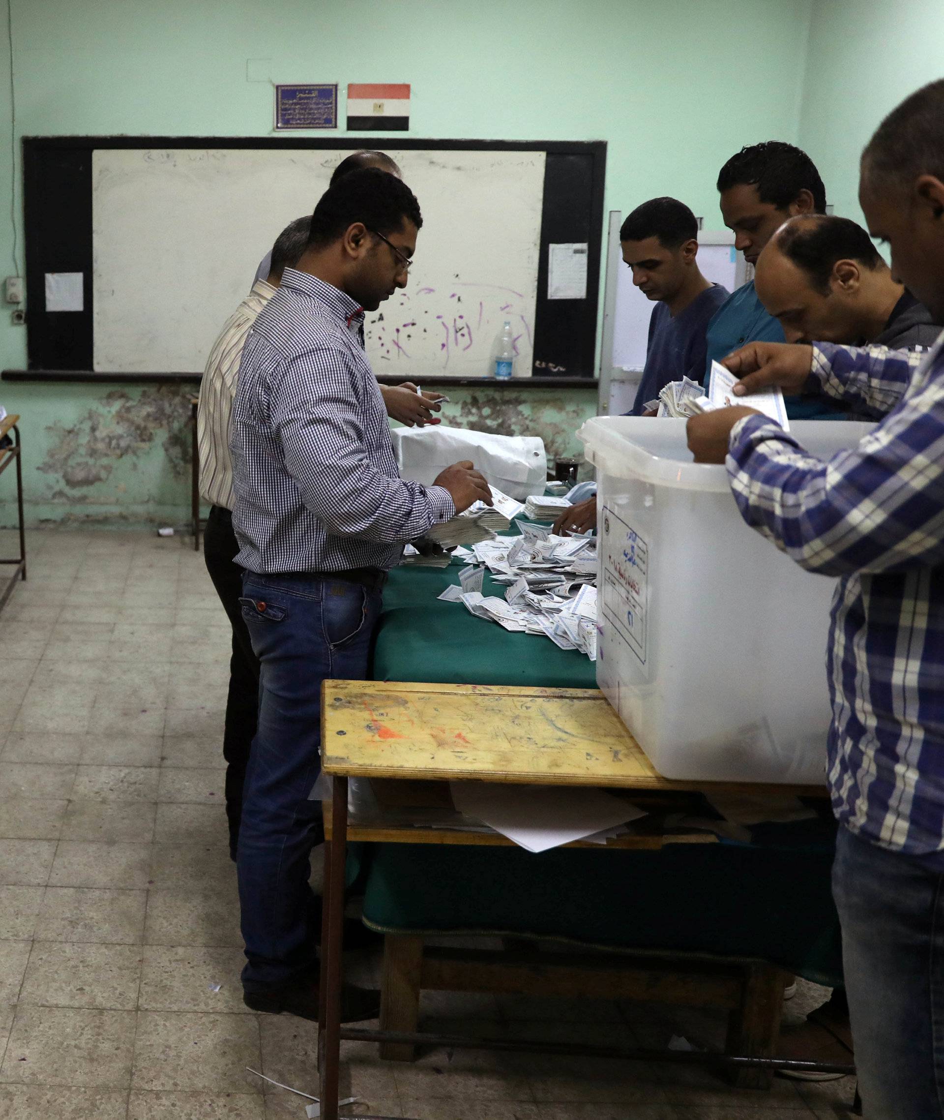 Electoral workers sort ballots to count votes after polls closed during the presidential election in Cairo