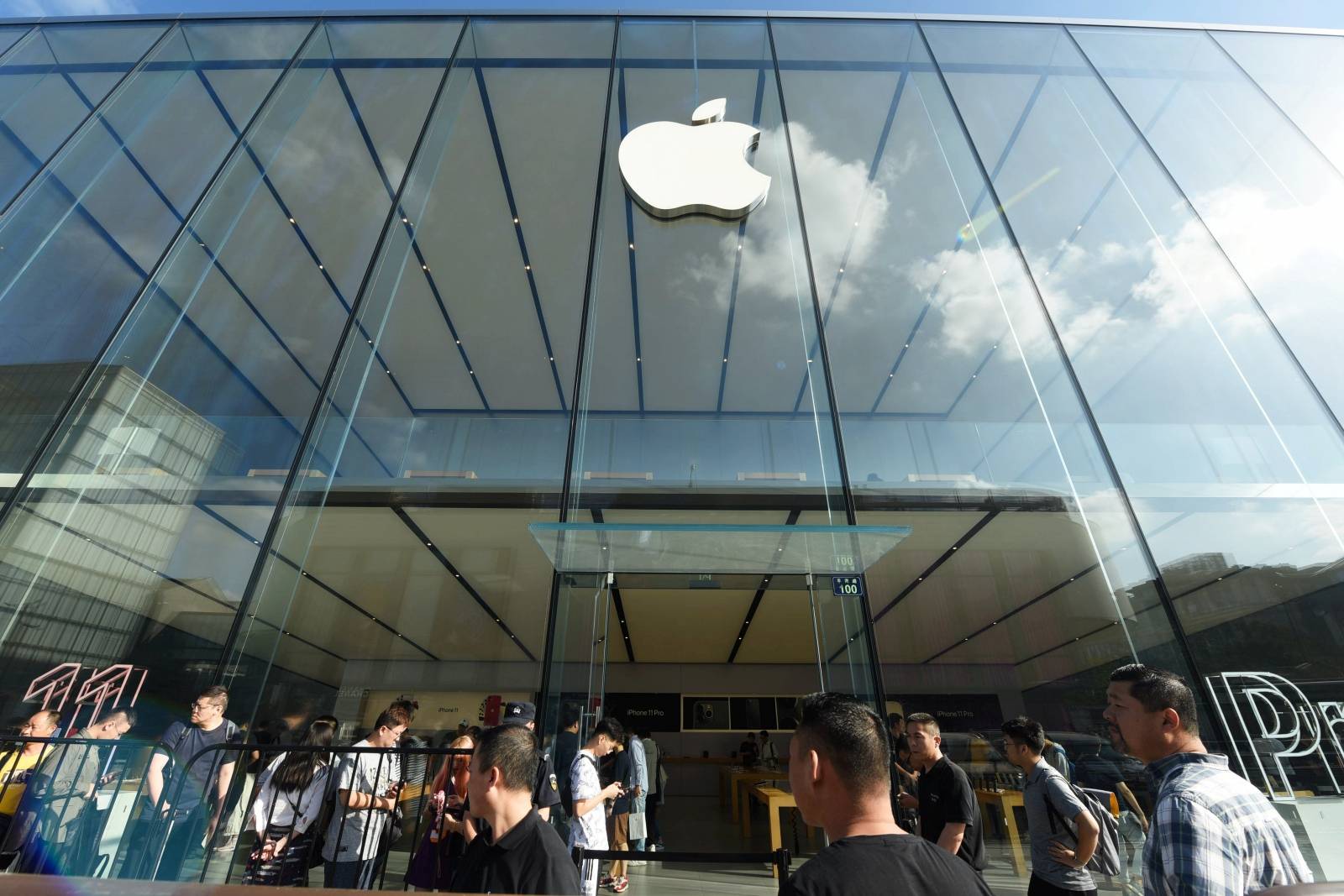 People queue outside an Apple store as the new iPhones go on sale, in Hangzhou