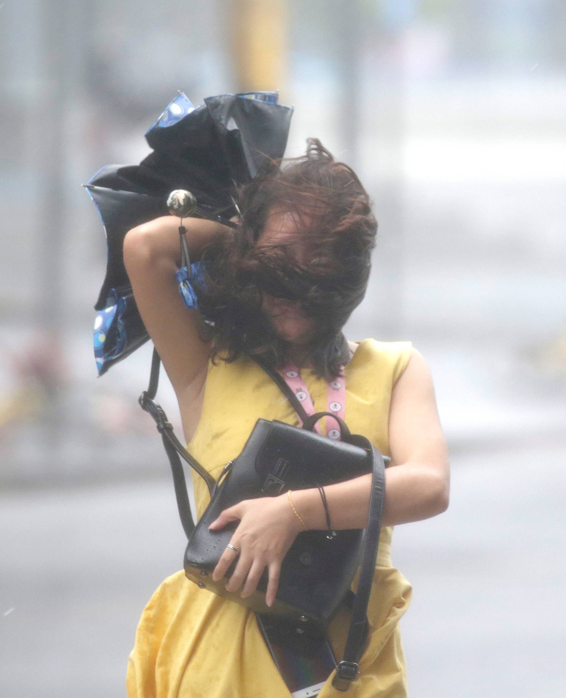 A woman walks in the rainstorm as Typhoon Mangkhut approaches in Shenzhen