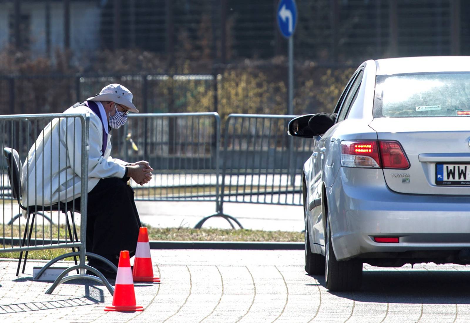 A priest wearing a protective mask gives a "drive-in confession" in front of a church following the coronavirus disease (COVID-19) outbreak in Warsaw