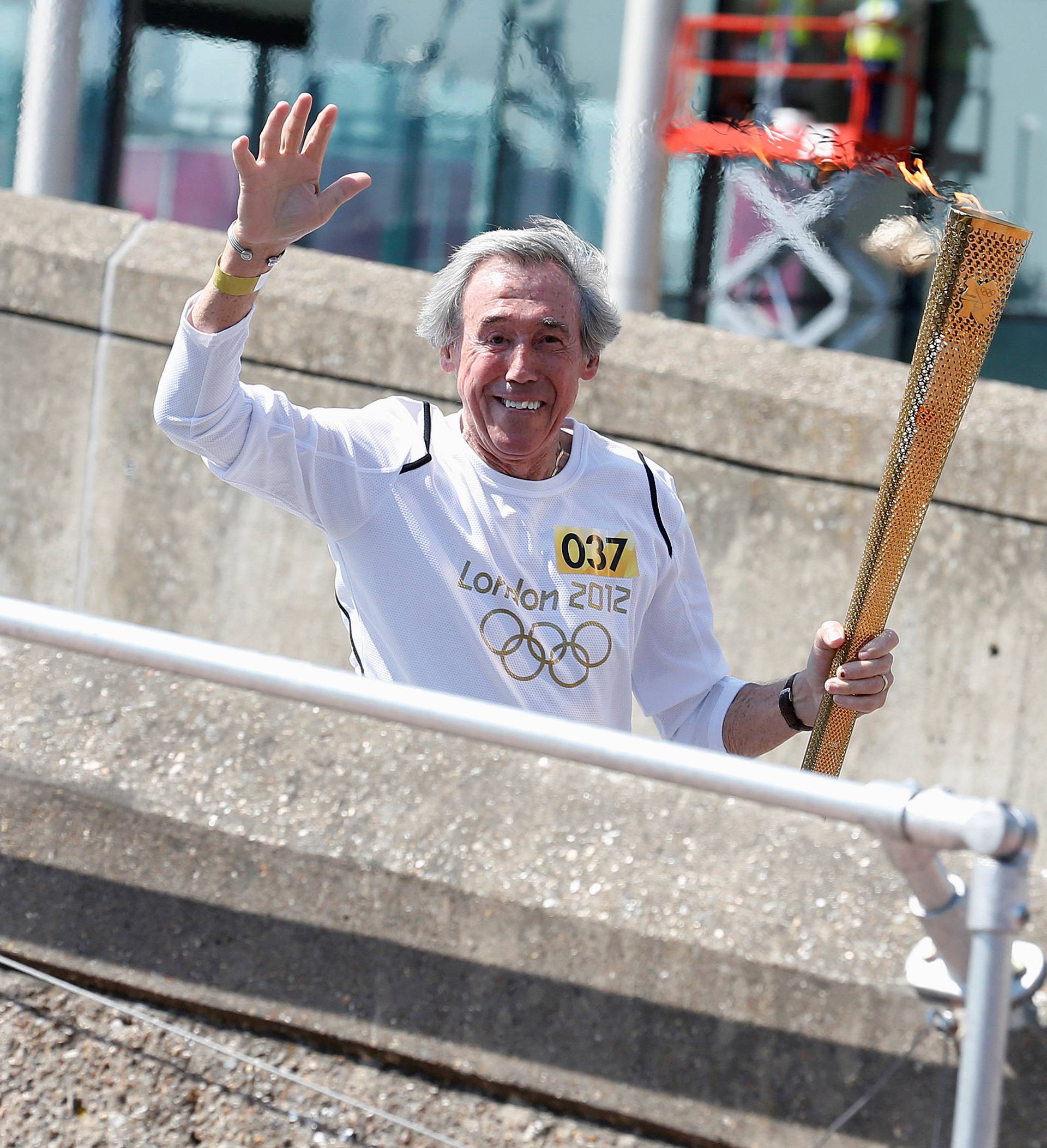 FILE PHOTO: British soccer player Banks, who was goalkeeper for England in the 1966 World Cup, runs with the London 2012 Olympic torch outside Wembley Stadium in northwest London