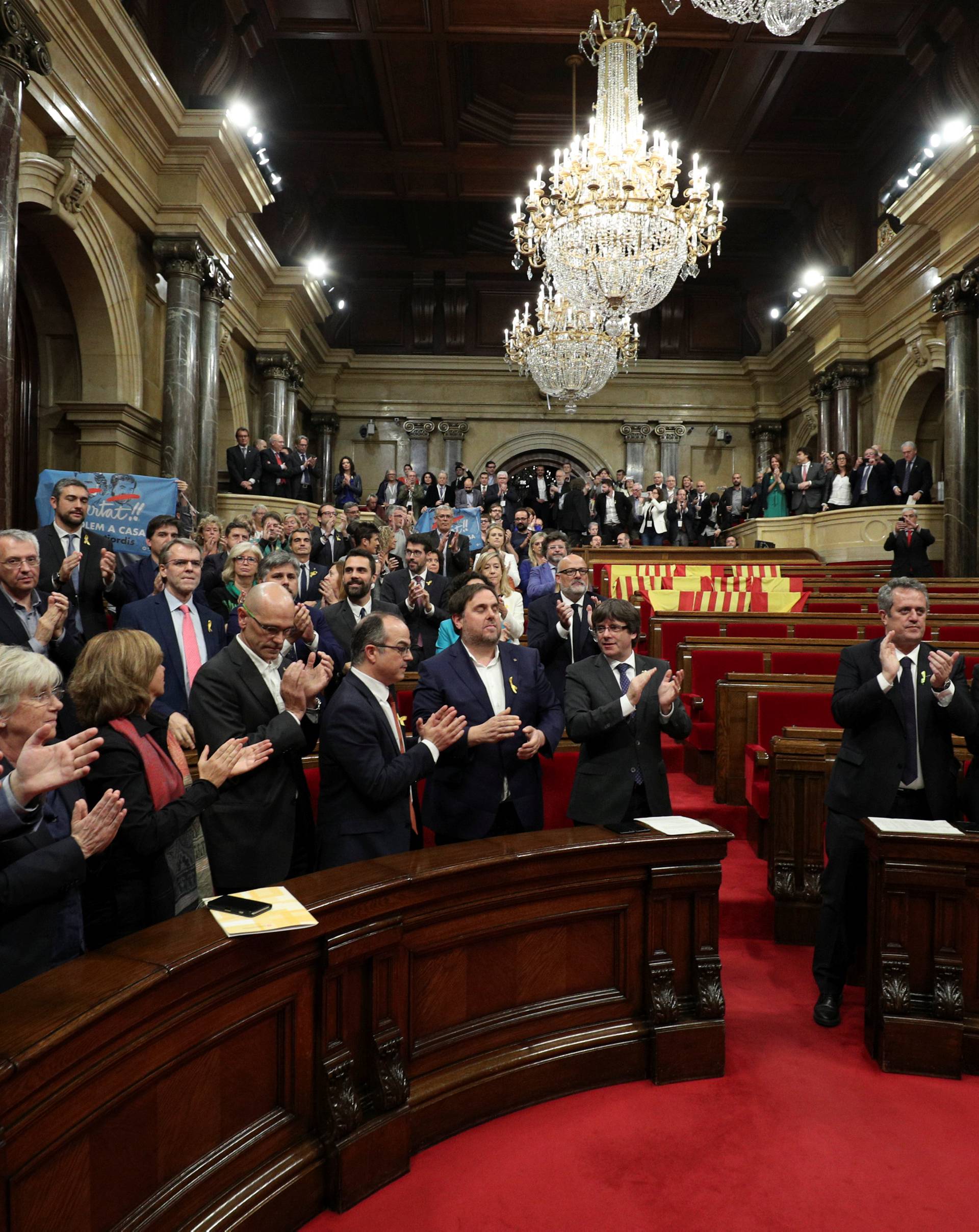 Catalan President Puigdemont and deputies applaud after the Catalan regional Parliament declared indpendence from Spain in Barcelona