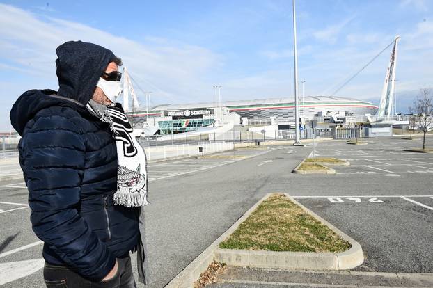 A man wearing a face mask is seen outside the Allianz Stadium in Turin