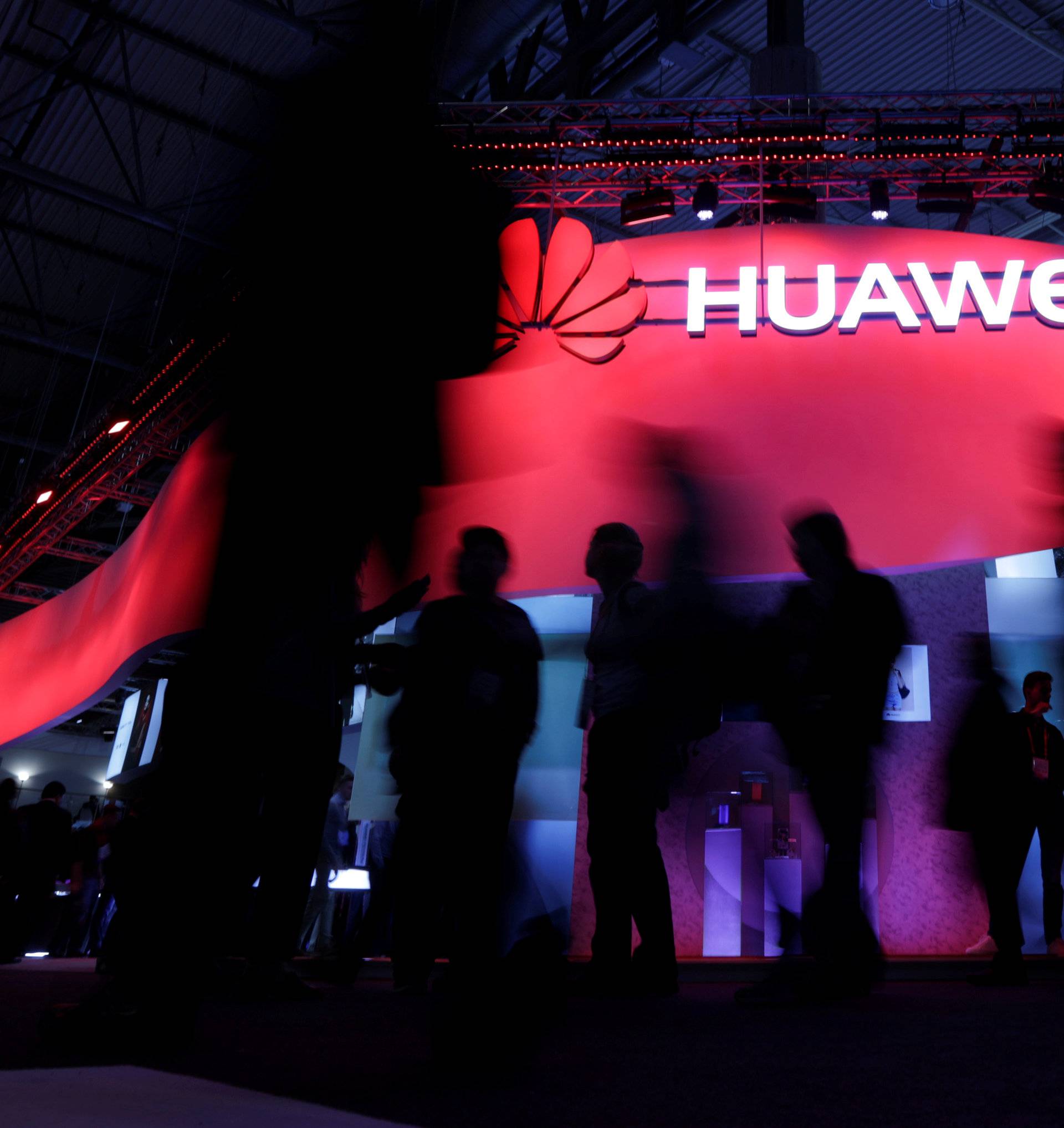 FILE PHOTO - Visitors walk past Huawei's booth during Mobile World Congress in Barcelona