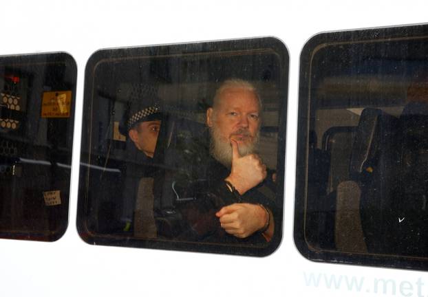 WikiLeaks founder Julian Assange is seen in a police van after was arrested by British police outside the Ecuadorian embassy in London