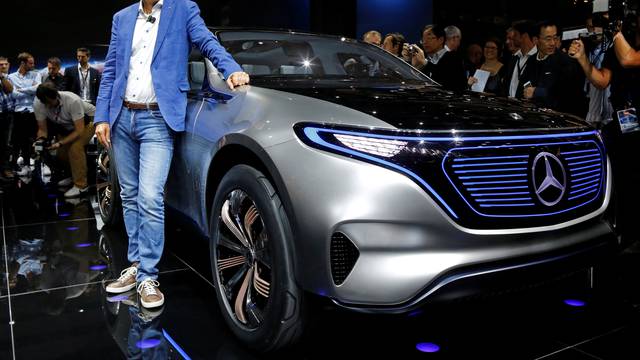 Dieter Zetsche, CEO of Daimler and Head of Mercedes-Benz, poses in front of a Mercedes EQ Electric car at the Paris auto show in Paris