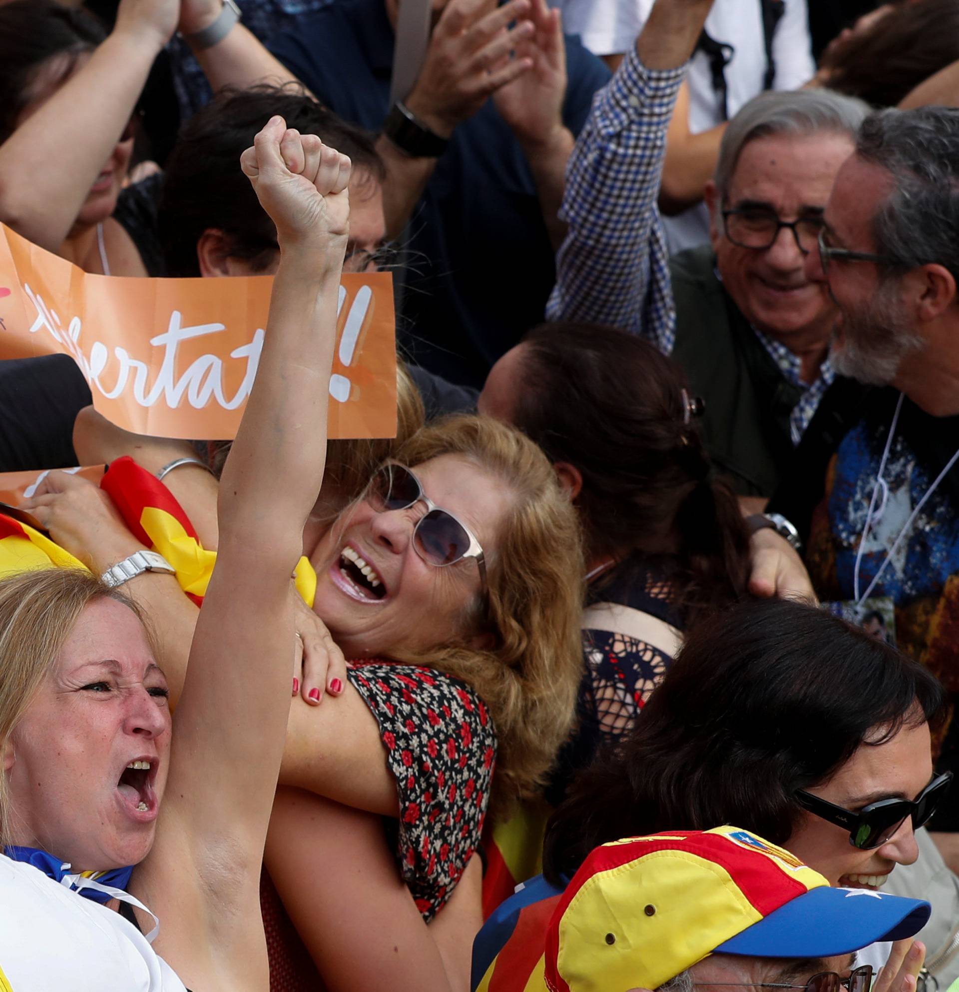 People react as they watch on giant screens a plenary session outside the Catalan regional parliament in Barcelona