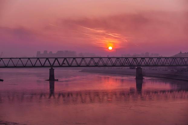 Izlazak sunca nad Dravom i željezničkim mostom u Osijeku
