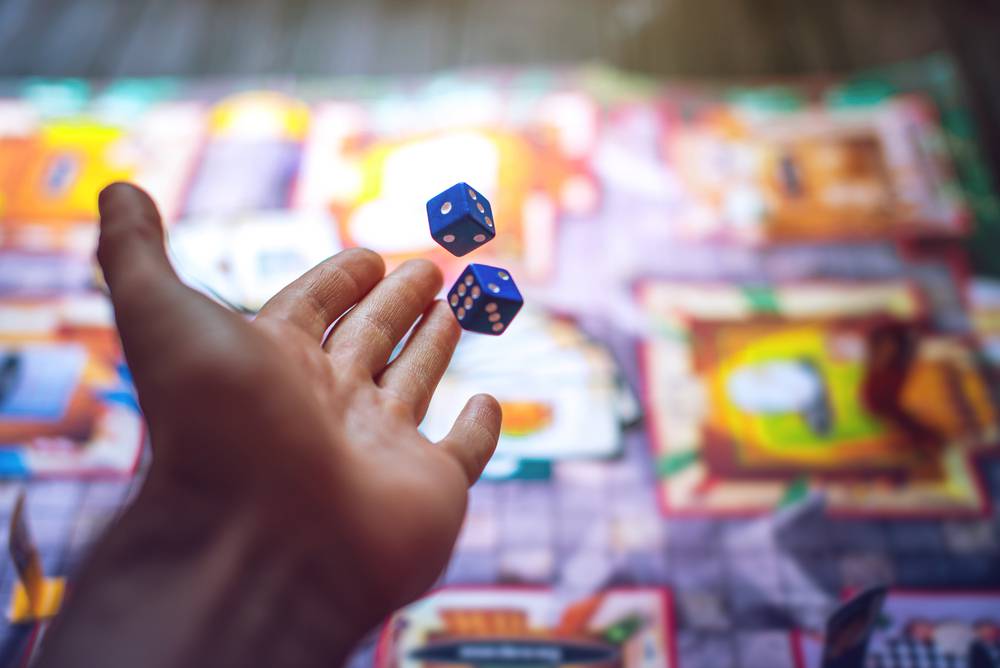 Hand,Throws,The,Dice,On,The,Background,Of,Colorful,Blurred