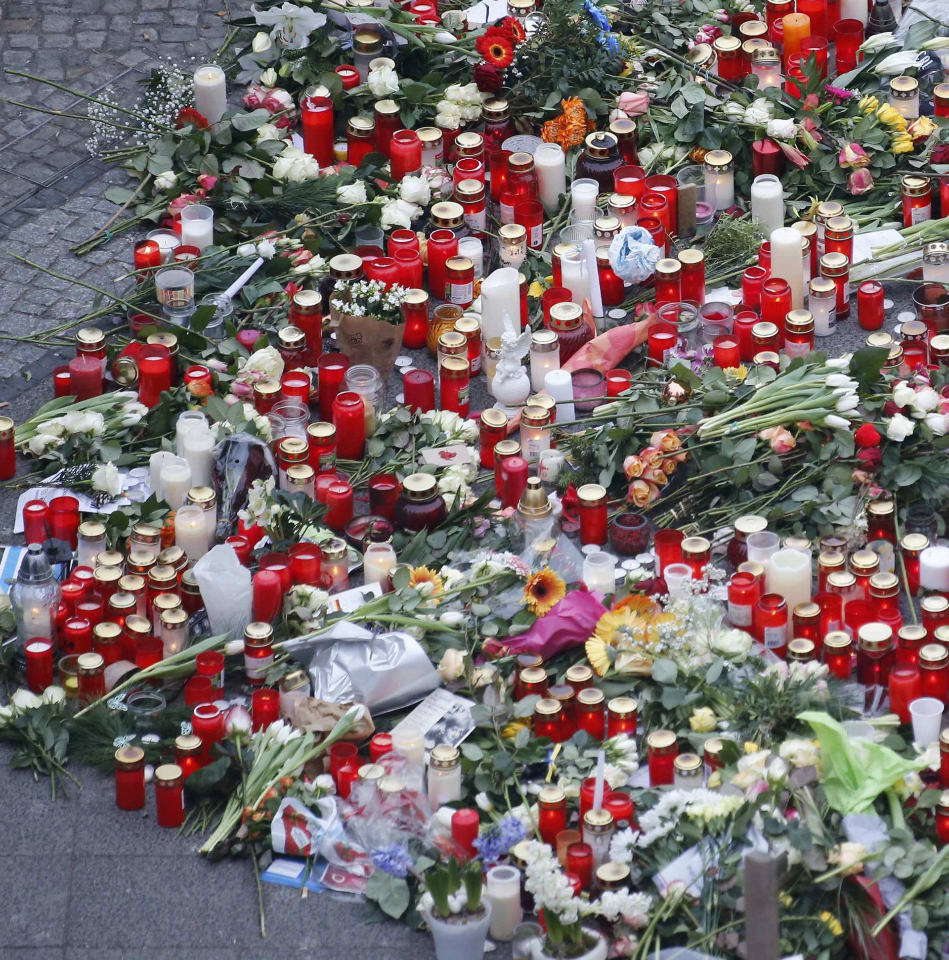 Flowers and candles are placed near the Christmas market in Berlin