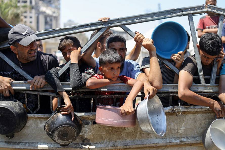 Palestinians receive food from charity kitchen, in Gaza City