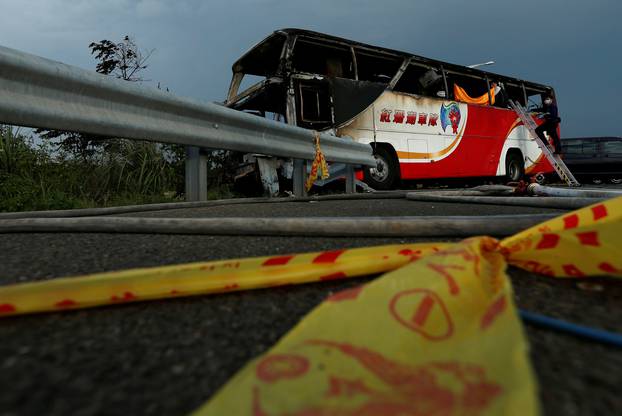 Police work around the wreckage of a bus that crashed en route to Taoyuan airport, just south of the capital Taipei, Taiwan 