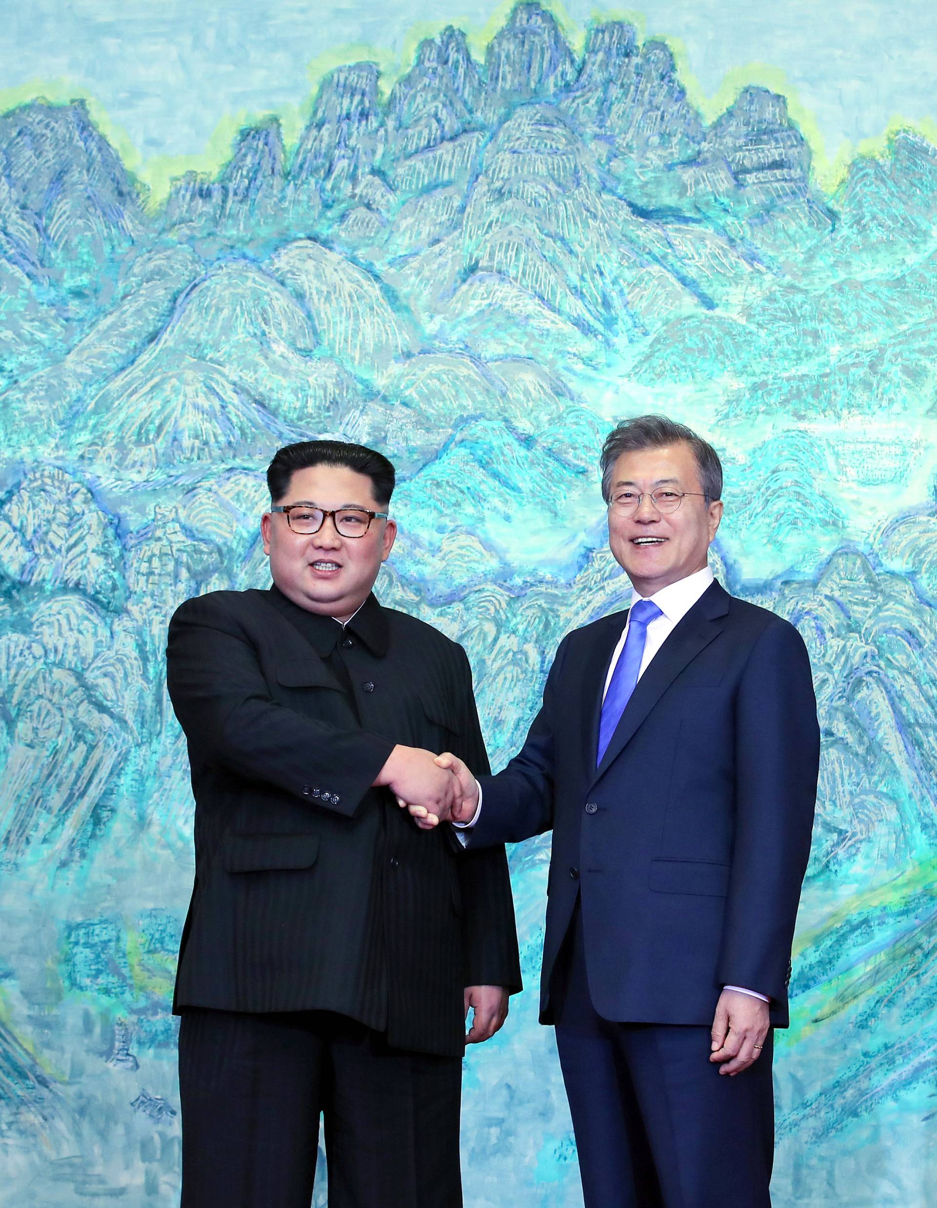 South Korean President Moon Jae-in shakes hands with North Korean leader Kim Jong Un during their meeting at the Peace House