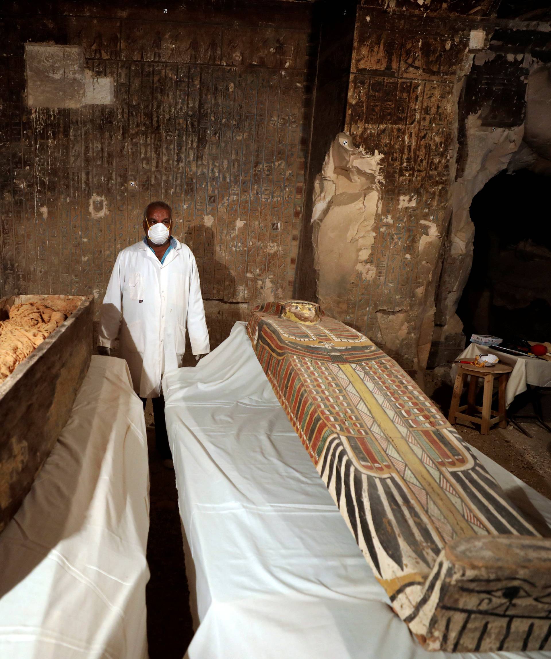 An archaeologist  stands near an intact sarcophagus inside the tomb TT33 in Luxor