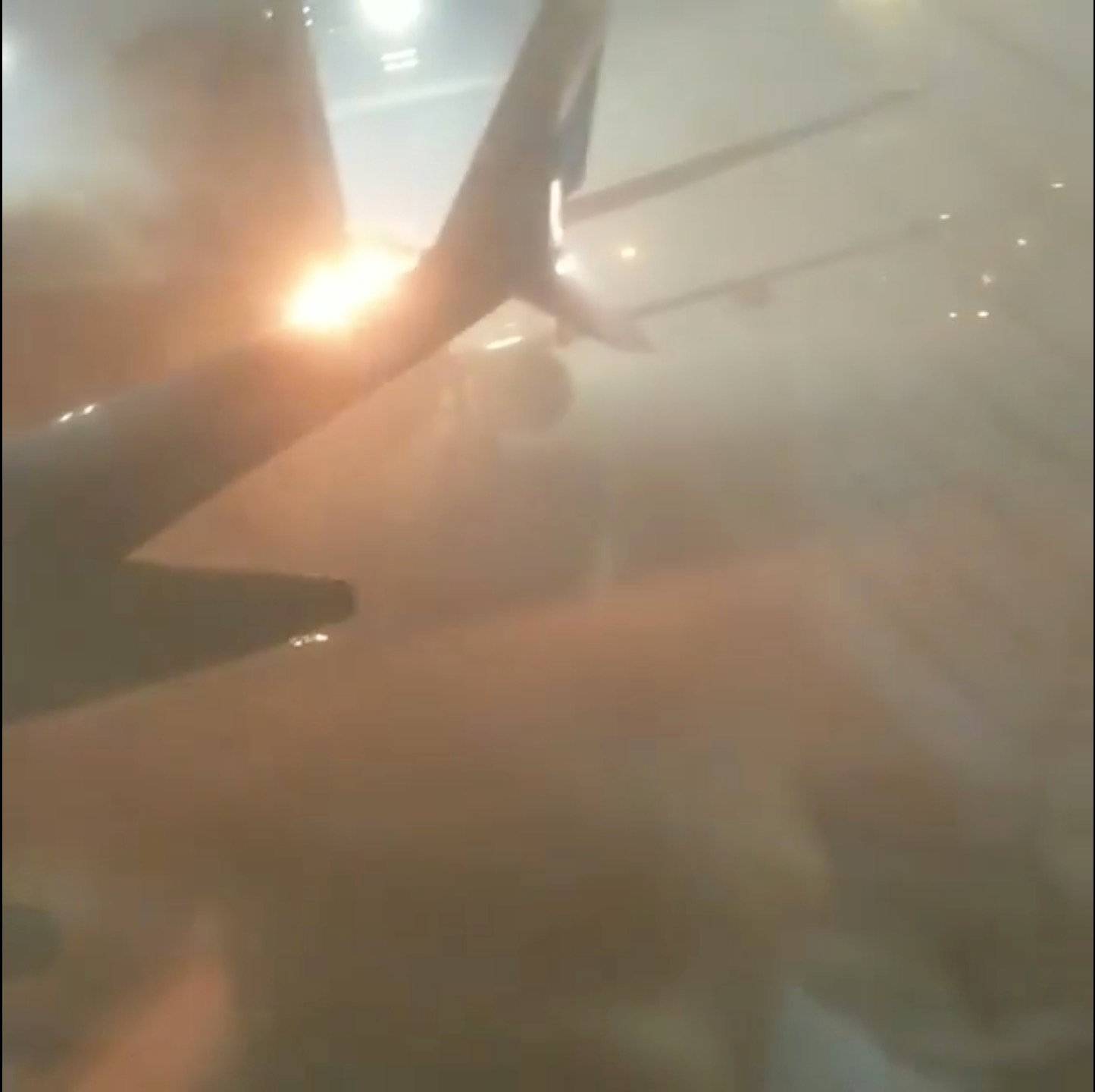 An explosion is seen through a window of a plane that has collided with another plane at Toronto's Pearson Airport, Canada